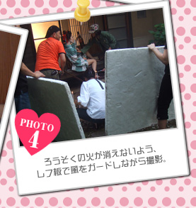 ろうそくの火が消えないよう、レフ板で風をガードしながら撮影。